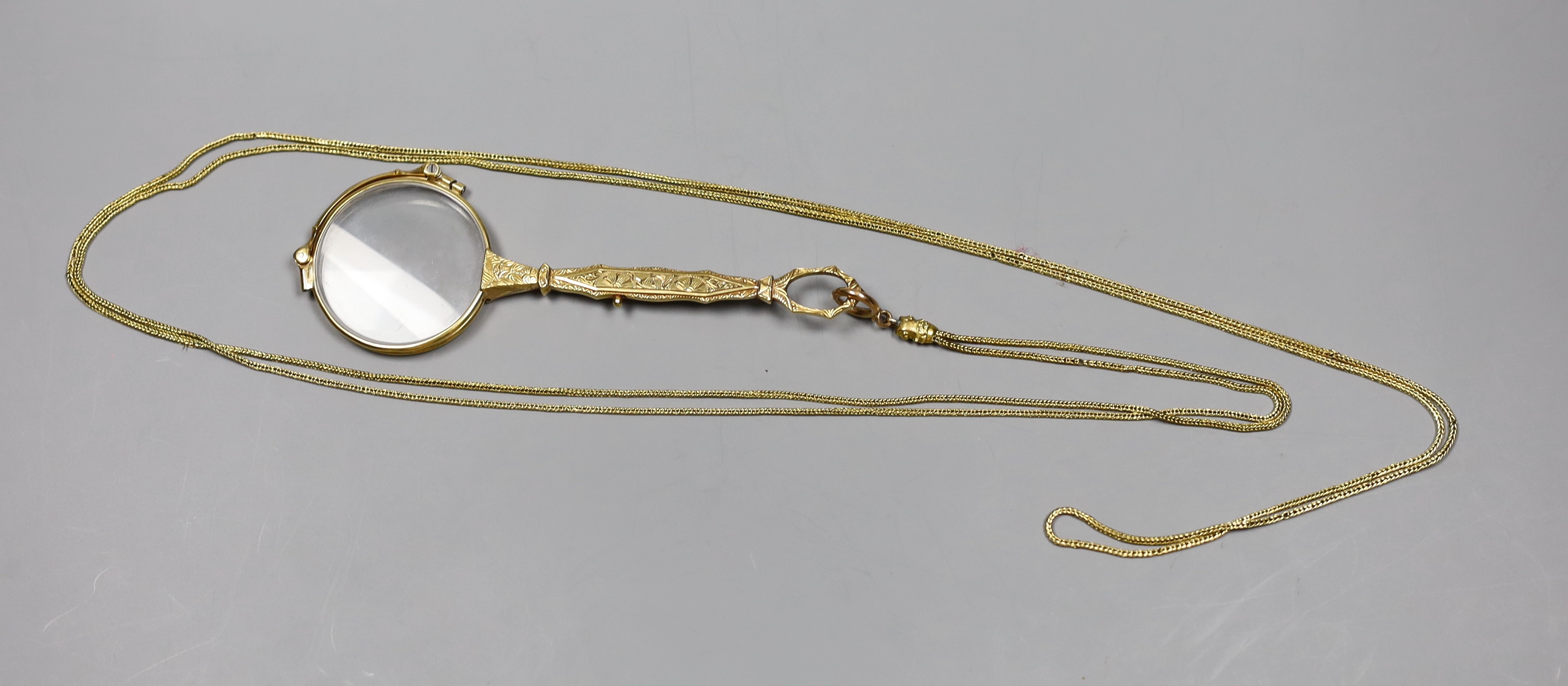 A pair of Austro-Hungarian engraved 585 yellow metal lorgnettes, on a yellow metal fine link guard chain, 145cm